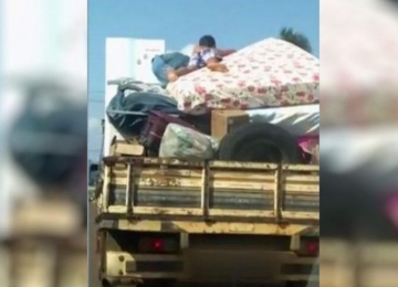 Criança é flagrada em cima de móveis em carroceria
