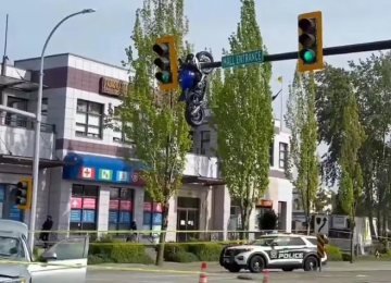 Motocicleta fica pendurada em semáforo após colisão e cena impressiona moradores no Canadá