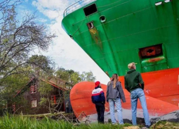 Navio porta-contêineres de 135 metros encalha no jardim de morador na Noruega